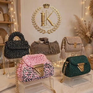 Peut inclure: Cinq sacs à main crochetés en noir, marron, rose et noir, beige et vert foncé. Chaque sac dispose d'un fermoir en métal doré, d'une fermeture à rabat et d'une bandoulière en chaîne dorée. Le sac beige comporte deux pompons décoratifs.