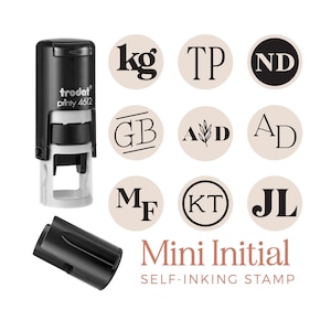 May include: A black self-inking stamp with the text "trodat printy 4612" and a black cap. The image shows nine beige circular designs with initials, and the words "Mini Initial SELF-INKING STAMP" in a reddish-brown colour.