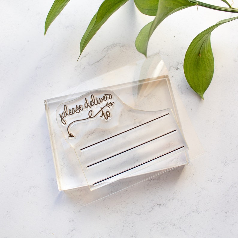May include: Clear acrylic stamp with the text "please deliver to" and a small arrow. The stamp has three lines for writing.