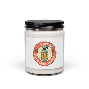 Può includere: Una candela bianca in un barattolo di vetro trasparente con coperchio nero. L'etichetta presenta un emblema circolare arancione e rosso con un personaggio a forma di flacone spray e il testo Fart Fart Deodorizer in un font stile retro.
