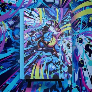 May include: A rectangular binder featuring a vibrant, multi-colored graphic illustration of the blue creature Blastoise. The design includes dynamic streaks of yellow, pink, and cyan against a dark background, with a solid light blue spine.