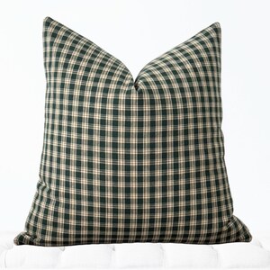 May include: A green and cream plaid throw pillow with a square shape.