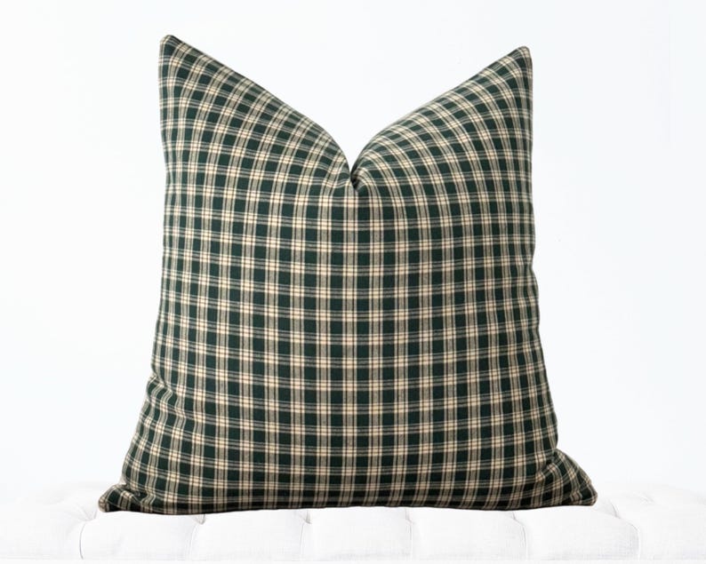 May include: A green and cream plaid throw pillow with a square shape.