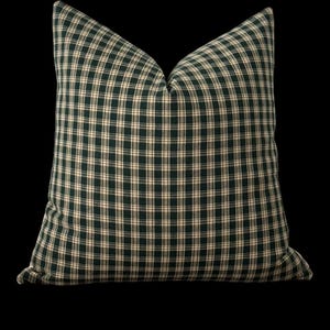 May include: A green and white plaid throw pillow with a square shape.