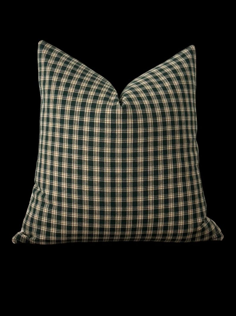 May include: A green and white plaid throw pillow with a square shape.