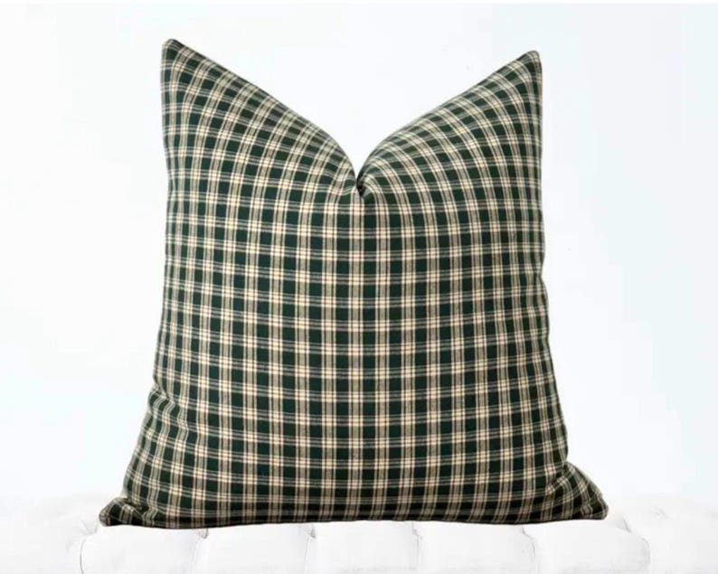 May include: A green and cream plaid throw pillow with a square shape.