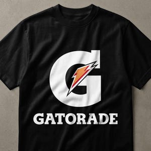 Könnte beinhalten: Ein schwarzes Kurzarm-T-Shirt mit einem großen weißen G-Logo, das einen orangefarbenen und roten Blitz enthält. Das Wort GATORADE ist in weißen Großbuchstaben direkt unter dem großen G-Logo auf der Vorderseite des T-Shirts aufgedruckt.