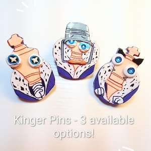 Puede incluir: Tres pines que muestran un personaje con cabeza en forma de pieza de ajedrez color canela, ojos azules y una túnica morada con borde blanco y manchas negras. El texto "Kinger Pins - 3 available options!" es visible.