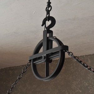 Op de afbeelding: Zwarte metalen katrol met een ketting eraan bevestigd. De katrol heeft een rond wiel met een kruisvormig ontwerp. De ketting is aan de bovenkant van de katrol bevestigd en hangt aan beide kanten naar beneden.