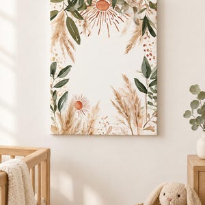 May include: A rectangular canvas wall art print featuring a watercolor illustration of pampas grass, green leaves, and two terracotta-colored sunburst motifs. The design frames a central white space with soft botanical elements in beige and green.