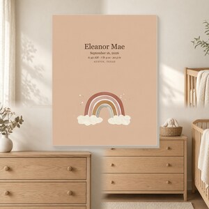 May include: A rectangular wall art print featuring a solid peach background with the text Eleanor Mae, September 16, 2026, 6:42 AM, 7 lb 4 oz, 20.5 in, and Austin, Texas. Below the text is a graphic of a multi-colored rainbow with white clouds.