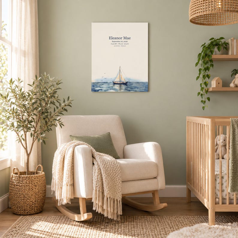 Sailboat canvas in a nursery on a sage green wall above a cream rocking chair, showing sample name Eleanor Mae and birth details.