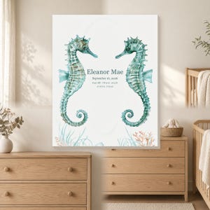 May include: A rectangular wall art print featuring two watercolor seahorses in shades of teal facing each other. The text reads Eleanor Mae, September 16, 2026, 6:42 AM, 7 lb 4 oz, 20.5 in, Austin, Texas. Below are illustrations of coral and seaweed.