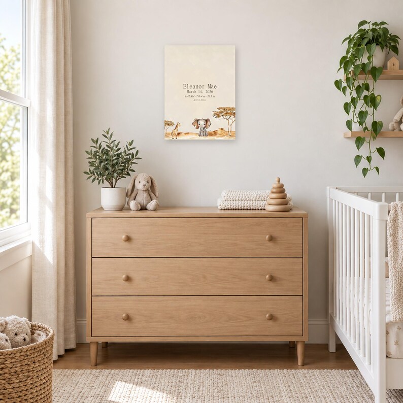 Safari birth stats sign in a nursery above a light oak dresser beside a white crib, showing sample name Eleanor Mae and birth details.