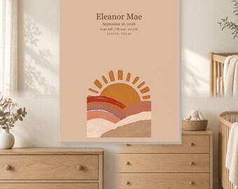 Op de afbeelding: Een rechthoekige wandkunstprint met een licht perzikkleurige achtergrond en de tekst Eleanor Mae, 16 september 2026, 06:42 uur, 3,29 kg, 52,07 cm en Austin, Texas. Onder de tekst staat een afbeelding van een zon die opkomt boven gelaagde heuvels in oranje, rood en beige.