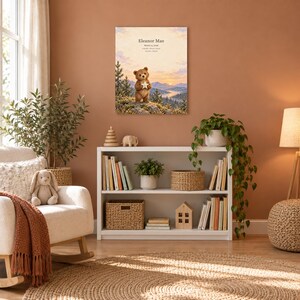 Woodland bear canvas in a nursery on a terracotta wall above a white bookshelf, showing sample name Eleanor Mae and birth details.