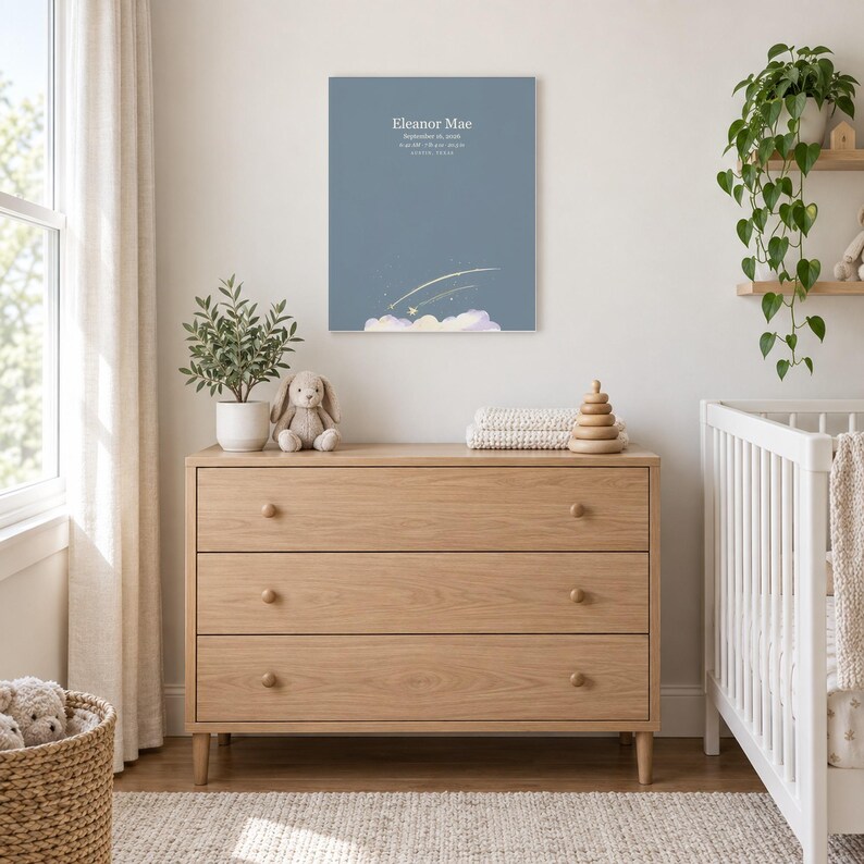 Shooting star canvas in a nursery above a light oak dresser beside a white crib, showing sample name Eleanor Mae and birth details.