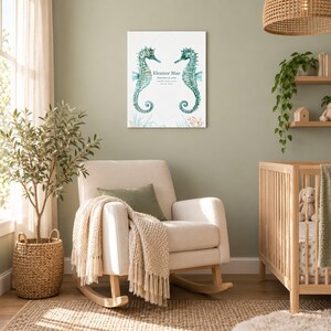 Seahorse reef canvas in a nursery on a sage green wall above a cream rocking chair, showing sample name Eleanor Mae and birth details.