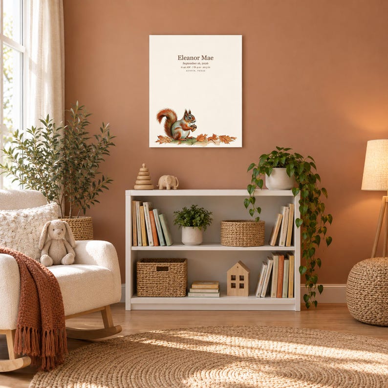 Little squirrel canvas in a nursery on a terracotta wall above a white bookshelf, showing sample name Eleanor Mae and birth details.