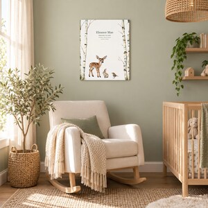 Meadow fawn canvas in a nursery on a sage green wall above a cream rocking chair, showing sample name Eleanor Mae and birth details.