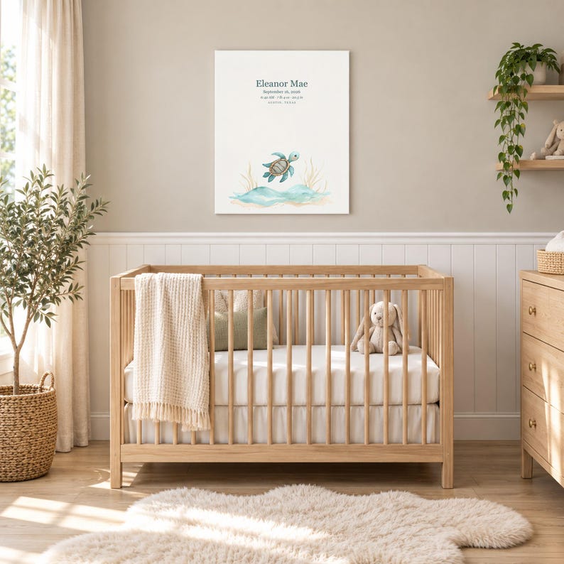 Sea turtle canvas in a nursery on a greige wall above a wooden crib and white wainscoting, showing sample name Eleanor Mae and birth details.