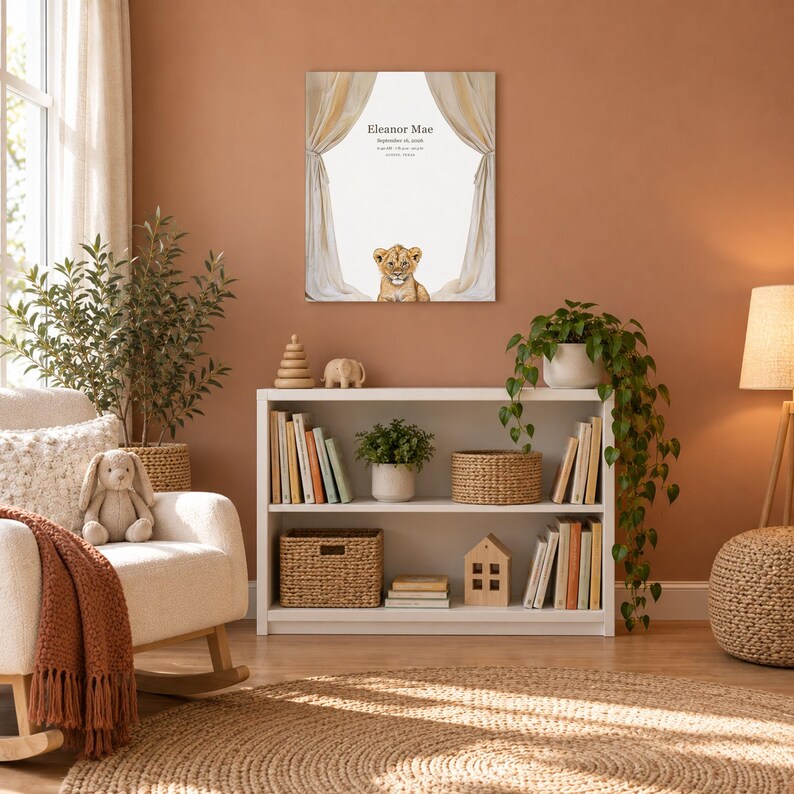 Lion cub canvas in a nursery on a terracotta wall above a white bookshelf, showing sample name Eleanor Mae and birth details.