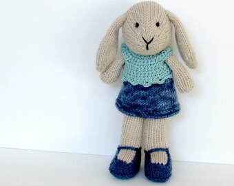 Knitted bunny doll wearing green knit top and denim skirt.  Custom personalize with an initial.