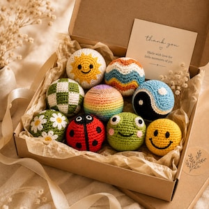 Crochet sensory ball gift set arranged in a keepsake box, handmade baby shower gift featuring colorful textured amigurumi balls.