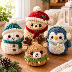 Puede incluir: Cuatro figuras de ganchillo que incluyen un muñeco de nieve blanco con gorro y bufanda verde azulado, un oso beige con gorro de Papá Noel rojo, un reno marrón con collar de cascabeles verde y un pingüino azul con orejeras y bufanda verde claro.
