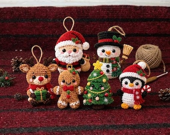 May include: A collection of six crocheted Christmas ornaments featuring a reindeer with a gift, Santa Claus, a snowman with a broom, a gingerbread person, a decorated Christmas tree, and a penguin wearing a Santa hat and scarf.