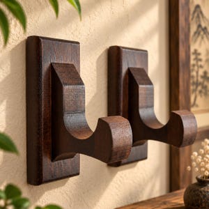 May include: Two dark brown wooden wall hooks with a rectangular base and a curved, protruding support arm. The hooks feature a visible wood grain texture and a smooth, polished finish, designed for mounting items securely to a flat vertical surface.