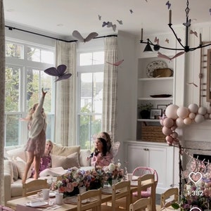 Puede incluir: Una mesa de fiesta para ni&ntilde;os con decoraciones rosas y blancas. La mesa est&aacute; puesta con manteles individuales rosas, platos blancos y vasos rosas. Tambi&eacute;n hay globos rosas y blancos en el fondo. El texto "1,382" y "145" es visible en la imagen.
