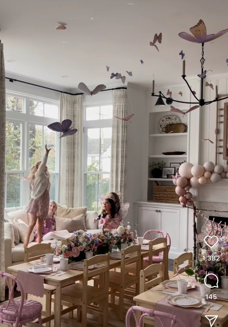 Puede incluir: Una mesa de fiesta para ni&ntilde;os con decoraciones rosas y blancas. La mesa est&aacute; puesta con manteles individuales rosas, platos blancos y vasos rosas. Tambi&eacute;n hay globos rosas y blancos en el fondo. El texto "1,382" y "145" es visible en la imagen.