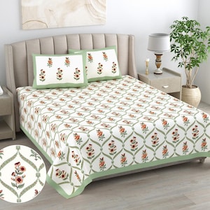 May include: A white bed sheet and two matching pillowcases featuring a repeating pattern of orange and green floral motifs enclosed within a sage green lattice design. The bedding set includes a solid sage green border along the edges.
