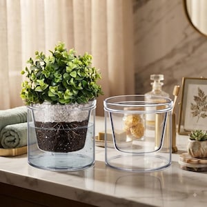 May include: Two clear, cylindrical double-walled glass planters. One planter holds a green leafy plant with visible soil and roots, while the other is empty. The planters feature a transparent design with a distinct inner vessel for soil.