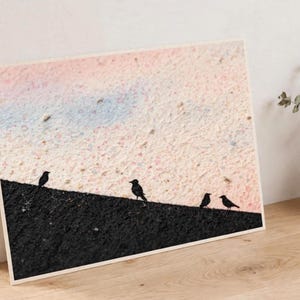 Könnte beinhalten: Ein rechteckiger Wandkunstdruck mit einem strukturierten, hellrosa und blassblauen Hintergrund über einem soliden schwarzen diagonalen Bereich. Vier kleine, schwarze Vogelsilhouetten sitzen entlang der scharfen Trennlinie.