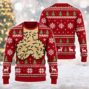 May include: A red long-sleeve crewneck jumper featuring a repeating holiday pattern of white snowflakes, green pine trees, and white reindeer. The front centre displays a large, beige, abstract graphic with black textured markings.