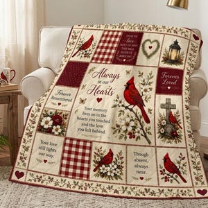 Könnte beinhalten: Eine gesteppte Tagesdecke mit Patchwork-Design, roten Kardinälen, weißen Blumen und Karomustern. Der Text lautet: Always in our Hearts, Forever Remembered, Forever Loved sowie Gedenksprüche. Die Decke hat einen cremefarbenen Hintergrund.
