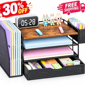 May include: A black metal desk organizer with a wood-grain top shelf, a digital clock displaying 05:28, three tiered paper trays, a side file holder, and a bottom drawer. The unit holds colorful paper, markers, and small office supplies.