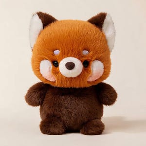 May include: A plush red panda toy featuring a soft, rust-orange head with white ear tips and cheek patches, dark brown eyes, and a small dark nose. The body is covered in dark brown fur, creating a distinct contrast with the lighter head.