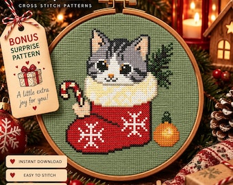 Könnte beinhalten: Ein Kreuzstichmuster in einem Holzrahmen mit einer grau-weißen Katze in einem roten Weihnachtsstrumpf mit weißen Schneeflocken. Die Katze hält eine Zuckerstange. Ein Etikett am Rahmen zeigt WonderByStitch und Bonus Surprise Pattern.