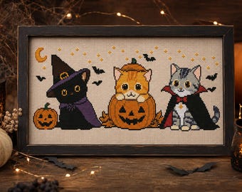 Puede incluir: Un bordado en punto de cruz enmarcado que muestra tres gatos con disfraces de Halloween: un gato negro con sombrero de bruja y capa morada, un gato naranja dentro de una calabaza y un gato gris con capa de vampiro y pajarita roja.