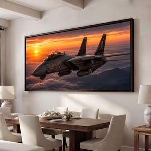 May include: A rectangular wall art print featuring a Grumman F-14 Tomcat fighter jet flying above clouds at sunset. The aircraft is dark gray with a skull and crossbones emblem on the tail fin. The sky is filled with vibrant orange and yellow light.