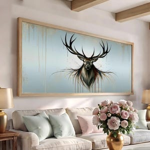 May include: A rectangular wall art piece featuring a stylized deer head with large antlers centered on a light blue background. The artwork displays vertical paint drips in gold and dark tones, creating a textured effect within a light wood frame.