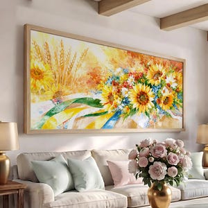 May include: A rectangular wall art print in a light wood frame featuring an impressionistic painting of bright yellow sunflowers, golden wheat stalks, and colorful wildflowers with green and blue accents on a textured, warm-toned background.
