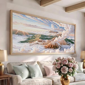 May include: A rectangular landscape wall art piece in a light wood frame depicting a volcanic mountain range above a sea of clouds. The scene features a smoking volcano, rugged brown terrain, green slopes, and a bright sunlit sky with soft clouds.