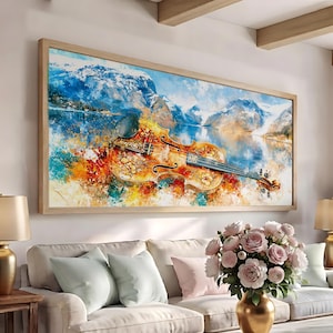 Puede incluir: Un cuadro rectangular de pared que muestra un violín con intrincados patrones florales en su cuerpo, sobre un paisaje pictórico vibrante de montañas nevadas y un lago azul tranquilo, todo dentro de un marco de madera clara.