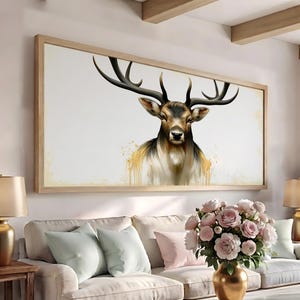 May include: A rectangular wall art piece featuring a detailed illustration of a deer with large antlers. The deer is rendered in shades of brown, black, and white, with gold-colored paint drip effects at the base, all enclosed in a light wood frame.