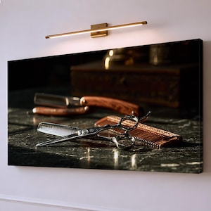 Könnte beinhalten: Ein rechteckiger Wandkunstdruck mit einer silbernen Haarschneideschere, die auf einem braunen Holzkamm liegt, sowie einem Rasiermesser mit Holzgriff dahinter, alles auf einer dunklen, reflektierenden, marmorähnlichen Oberfläche.