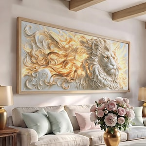 May include: A rectangular wall art piece featuring a relief-style depiction of a lion with a flowing, golden-toned mane. The artwork is encased in a light-colored wooden frame and displays a white lion head with intricate, swirling textures.